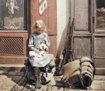 A girl sitting next to soldiers’ equipment in Reims, France, 1917